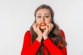 Portrait of young scared woman. Amazed horrified female keeps hands on mouth, being shocked to be expelled from university, look