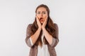 Portrait of young scared woman. Amazed horrified female keeps hands on mouth, being shocked to be expelled from university, look