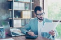 Portrait of young, serious accountant holding papers in hand and Royalty Free Stock Photo