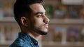 Portrait of young serious arabic model man with beard in plaid shirt standing indoors posing looking at camera close-up Royalty Free Stock Photo