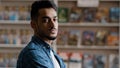 Portrait of young serious arabic model man with beard in plaid shirt standing indoors posing looking at camera close-up Royalty Free Stock Photo