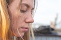 portrait of young serious blonde woman with a soulful and closed look, freckles on her face, close up. Shy pretty lady