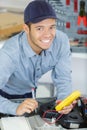 portrait young serviceman using multimeter on washing machine