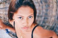 Portrait of young beautiful girl sitting on rattan hammock, blurry background Royalty Free Stock Photo