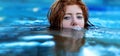 Portrait of young sexy playful woman with red hair, redhead, makes funny bubbles into water with mouth, swimming in the spa pool,