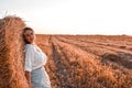 Portrait of young sexy woman on the haystack in morning sunlight, countryside. Beautiful woman in a dress sits on a Royalty Free Stock Photo