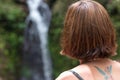 Portrait of young woman in the rainforest of tropical Bali island, Indonesia. Waterfall on a background. Rare view.