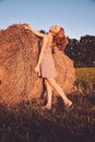 Portrait of young sexy woman with red hair on the haystack in morning sunlight, countryside. Beautiful woman in a dress Royalty Free Stock Photo