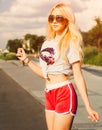 Portrait of young woman in Vintage T-shirt, red shorts and sunglasses posing on California beach Royalty Free Stock Photo