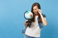 Portrait of young shocked concerned woman student with opened mouth with backpack removing glasses look on world globe Royalty Free Stock Photo