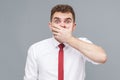 man closing his mouth with hand and looking at camera with shocked face and big eyes. Royalty Free Stock Photo