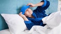 Portrait of young sick woman suffering from migraine putting wet cold towel on forehead Royalty Free Stock Photo