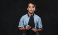 Portrait of a young skater boy dressed in a white t-shirt holds a longboard. Isolated on the dark background. Royalty Free Stock Photo