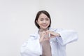 Portrait of a young and skilled doctor, medical student, intern posing while doing the heart sign with her hands. on a
