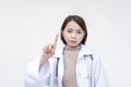 Portrait of a young and skilled doctor, medical student, intern posing with one finger up, scolding someone. Isolated on a white
