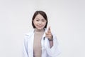 Portrait of a young and skilled doctor, medical student, intern, posing while pointing at the camera. on a white