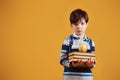 Portrait of young smart schooler in the studio against yellow background