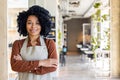 Portrait of a young smiling African-American woman who works in a catering establishment, restaurant. Standing in an Royalty Free Stock Photo