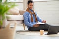 Portrait of smiling Arab man using laptop and writing Royalty Free Stock Photo