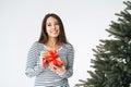 Portrait of young smiling asian woman with gift box in hands with Christmas tree on white background isolated Royalty Free Stock Photo