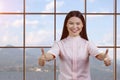 Portrait of young smiling asian woman giving two thumbs up. Royalty Free Stock Photo