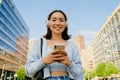 Portrait of young smiling beautiful asian girl holding phone Royalty Free Stock Photo