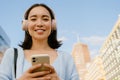 Portrait of young smiling beautiful asian girl holding phone Royalty Free Stock Photo