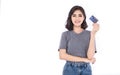 Portrait of young smiling beautiful Asian woman presenting credit card in hand. Royalty Free Stock Photo