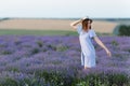 Portrait of young smiling beautiful woman in blue dress, hat on purple lavender flower blossom meadow field outdoors on Royalty Free Stock Photo