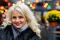 Portrait of a young smiling blonde woman against the background of defocused holiday lights. The concept of Christmas time. Copy Royalty Free Stock Photo