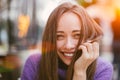 Portrait of young smiling brown-haired woman wearing violet sweater