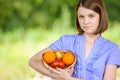 Portrait of young smiling brunette holding basket with fruits Royalty Free Stock Photo