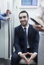 Portrait of young smiling businessman sitting on the subway and looking at camera Royalty Free Stock Photo