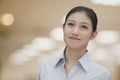 Portrait of young smiling businesswoman in a button down shirt, indoors, focus on foreground Royalty Free Stock Photo