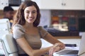 Portrait Of Young Smiling Businesswoman Working On Laptop At Desk In Office Royalty Free Stock Photo