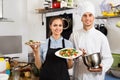 Smiling cook giving to waitress ready to serve salad Royalty Free Stock Photo