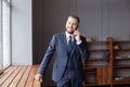 Portrait of young smiling cheerful entrepreneur in office making phone call Royalty Free Stock Photo