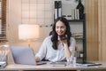 Portrait of a young, smiling, and cheerful entrepreneur working in a casual office, effortlessly multitasking by making Royalty Free Stock Photo