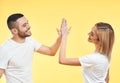 Portrait of young smiling couple giving high five to each other over studio background Royalty Free Stock Photo
