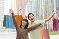 Portrait of young, smiling couple going shopping and holding colorful shopping bags on the street, outdoors in Beijing, China Royalty Free Stock Photo
