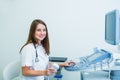 Portrait of young smiling doctor, ultrasound specialist looking at camera and using Ultrasound Scanning Machine for pacient Royalty Free Stock Photo