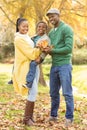 Portrait of a young smiling family holding leaves