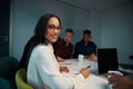 Portrait of young smiling female employee looking at camera while working at workplace