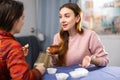 Portrait of young smiling girlfriends having fun together during drinking tea at table at home Royalty Free Stock Photo