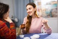 Portrait of young smiling girlfriends having fun together during drinking tea at table at home Royalty Free Stock Photo