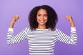 Portrait of young smiling good mood female showing power hands muscles isolated on purple color background