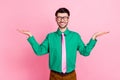 Portrait of young smiling guy wear green shirt hold hand comparsion prices shop isolated on pink color background