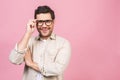 Portrait of young smiling handsome business man in casual shirt isolated on pink background touching his glasses Royalty Free Stock Photo