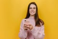 Portrait of young smiling happy cheerful friendly caucasian woman using mobile cell phone chat online, dressed in pink sweater Royalty Free Stock Photo