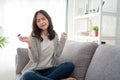 Portrait of young smiling and happy woman sitting on a sofa at home. She is holding a credit card. Concept of online shopping and Royalty Free Stock Photo